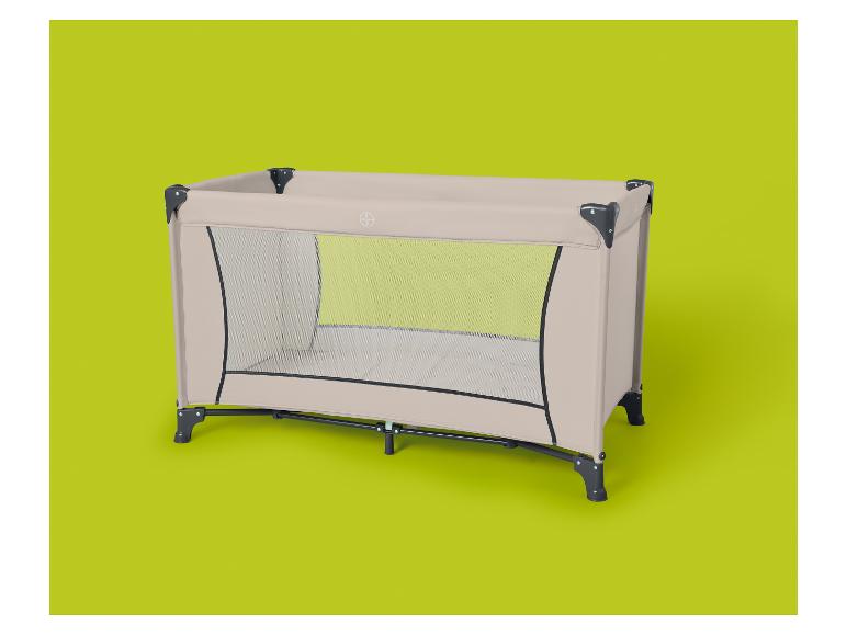 Lit de voyage pliable beige avec côtés en maille sur fond vert lime.