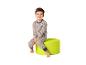 Garçon en pyjama imprimé dinosaure assis sur un pouf vert.