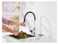 Un robinet de cuisine avec un bec de pulvérisation extractible est utilisé pour laver de la laitue.