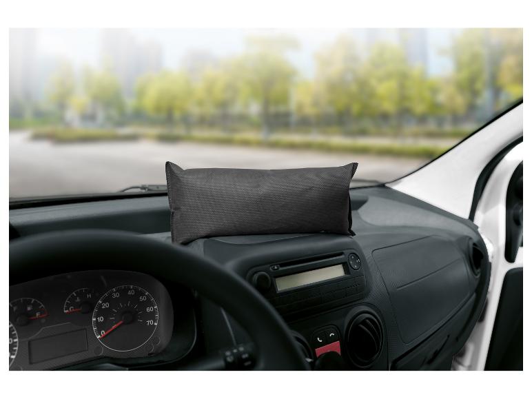 Sac rectangulaire noir sur le tableau de bord d'une voiture avec un paysage extérieur flou