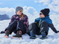 Deux enfants en vêtements d'hiver assis dans la neige.