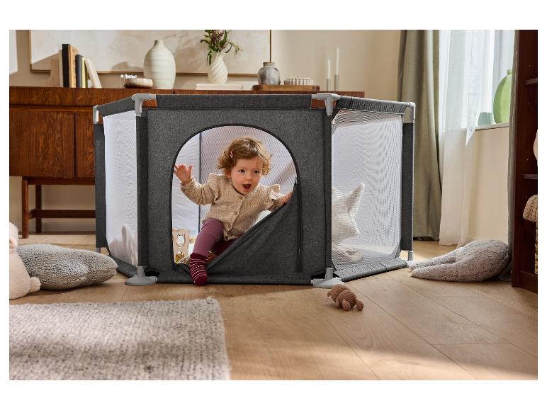 Bébé jouant dans un parc pour bébé gris LUPILU® dans une pièce chaleureuse.