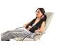 Une femme se relaxant dans un fauteuil avec un coussin de massage Shiatsu Beurer.
