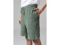 Un homme porte un short en éponge vert avec un motif abstrait.