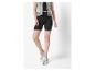 Modèle portant un short cycliste noir et des baskets blanches.