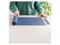 Un tapis de cuisson en silicone bleu Coox avec un ruban de mesure et une spatule en silicone séparée.
