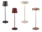 Quatre lampadaires modernes en noir, rouge, beige et cuivre, avec abat-jour géométriques et ronds.