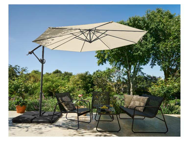 Ensemble de mobilier de jardin avec parasol, deux chaises, un banc et une table dans un jardin.