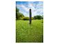 Housse de protection noire pour parasol sur pelouse.