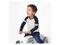 Enfant sur un jouet voiture rétro, vêtu d'un t-shirt à manches longues bicolore.