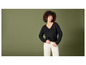 Une femme porte un pull noir et un pantalon blanc.