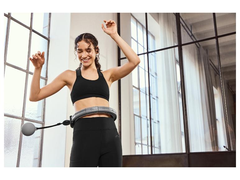 Une femme en tenue de sport utilise un anneau de fitness pendant un entraînement.