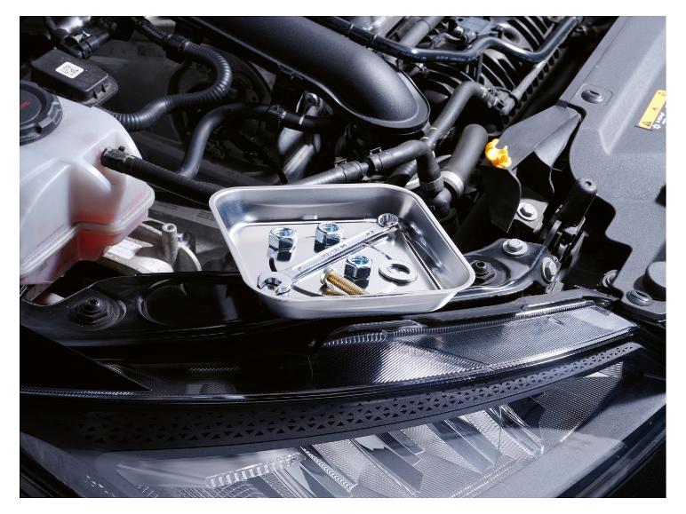 Outils et écrous dans le compartiment moteur d'une voiture