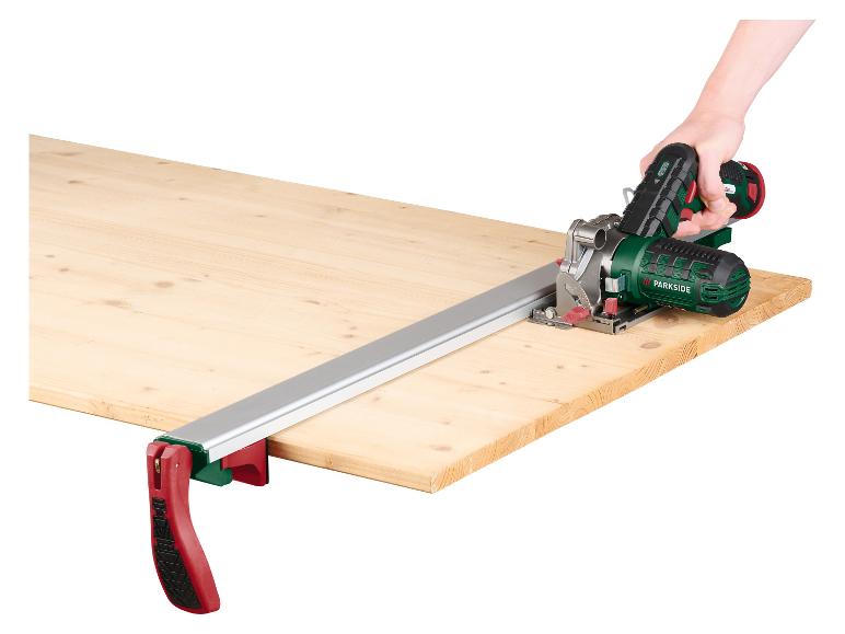 Scie circulaire PARKSIDE avec rail de guidage et serre-joints sur une planche en bois.