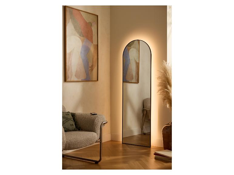 Miroir rétroéclairé dans un salon avec fauteuil et tableau abstrait.