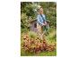Femme utilisant un aspirateur-souffleur de feuilles sans fil PARKSIDE 40 V dans un jardin