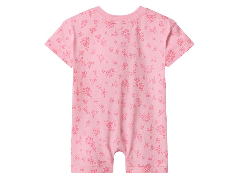 Barboteuse rose pour bébé à manches et jambes courtes, avec un motif floral subtil.
