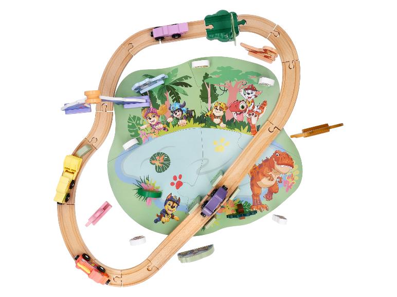 Circuit de train en bois avec des personnages de dessin animé et un dinosaure sur un tapis de jeu.
