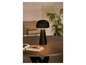 Une lampe noire en forme de champignon sur une table en bois avec un livre à côté.