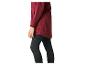Femme en veste rouge et leggings de sport noirs, vue latérale.