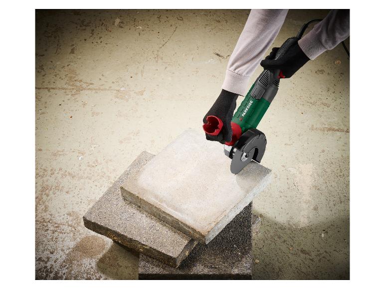 Une personne gantée utilise une meuleuse d'angle Parkside pour couper des dalles de béton.