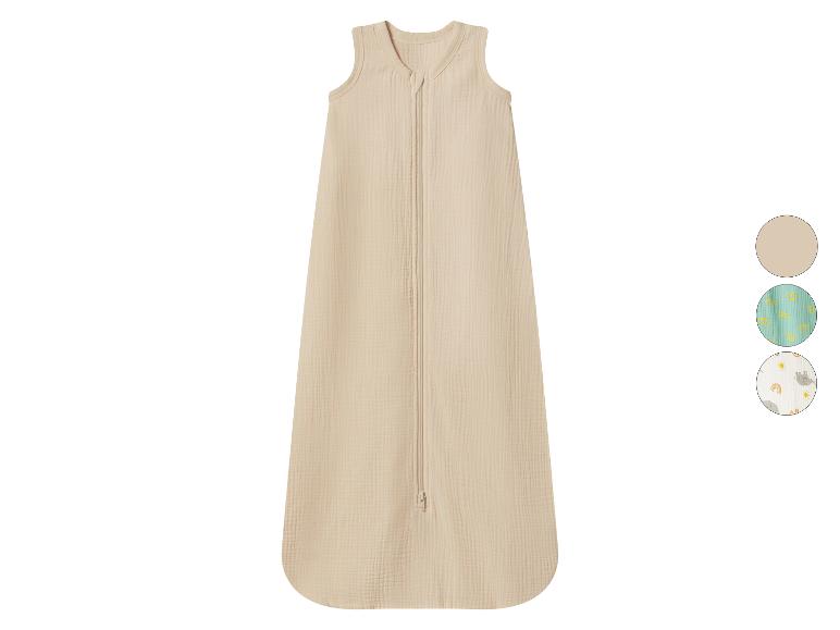 Gigoteuse bébé beige avec fermeture éclair frontale et échantillons de tissus.