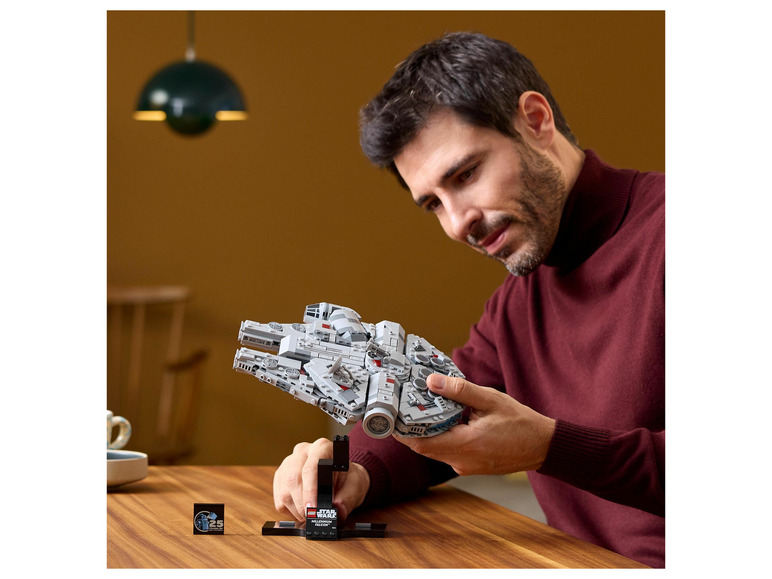 Un homme tient un LEGO Star Wars Millennium Falcon.