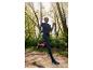 Femme courant dans une forêt avec des vêtements de sport et des chaussures Kalenji.