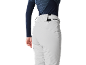 Femme en pantalon de ski gris clair et haut à manches longues bleu foncé.