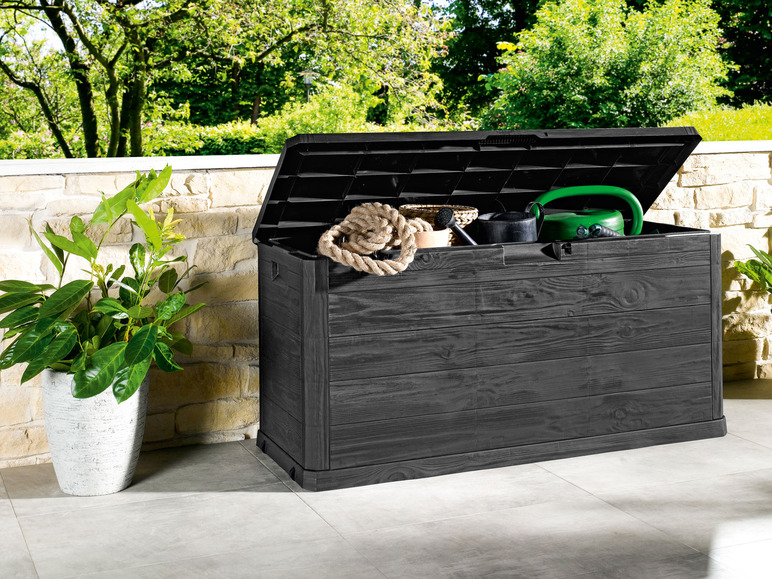 Une boîte de rangement noire à l'aspect bois, remplie d'outils de jardin.
