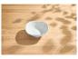 Bol blanc vide sur une table en bois avec des ombres de feuilles.