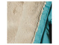 Détail d'une veste turquoise avec une doublure blanche en fourrure.