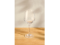 Verre à vin vide sur une table en bois avec des ombres en arrière-plan.