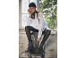 Femme en bonnet noir et chemise blanche assise sur une chaise avec des bottes noires.