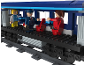 Train jouet en briques de construction avec des figurines de passagers et d'un contrôleur.