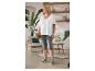 Femme en t-shirt blanc et leggings gris avec sac à main dans une pièce confortable.