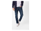 Homme en jeans bleus et baskets blanches.