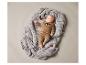 Un bébé allongé sur une couverture grise dans un pyjama marron avec un imprimé renard.