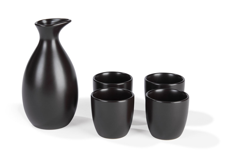 Un ensemble de sake noir avec une carafe et quatre verres.