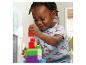 Un jeune enfant construit joyeusement une tour avec des blocs de jeu colorés Mega Bloks.