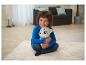 Un jeune garçon est assis par terre en train de câliner un husky en peluche.