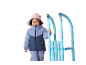 Petite fille joyeuse en vêtements d'hiver et bonnet, tenant une luge bleue.