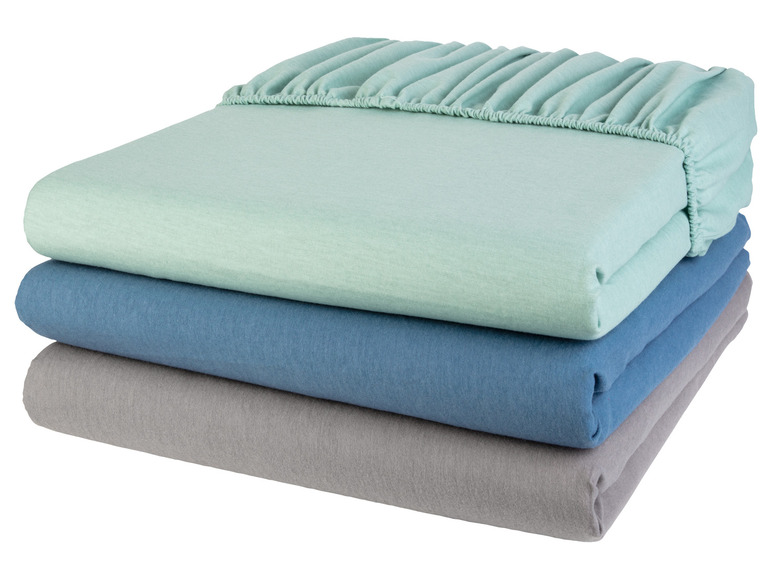 Un ensemble de draps-housses en vert, bleu et gris.