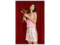 Une femme portant un haut rose et une jupe à fleurs.