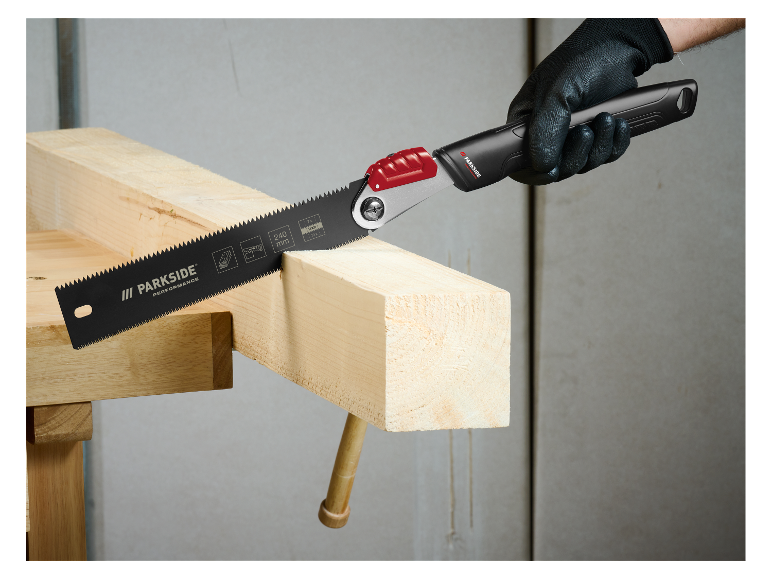 Un homme utilise une scie Parkside pour couper du bois.