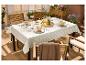Table d'extérieur dressée avec une nappe blanche et de la vaisselle.