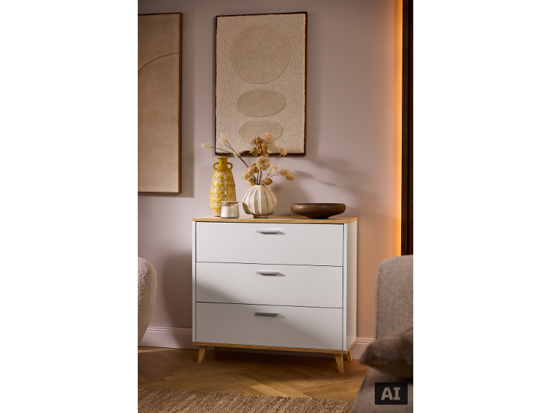 Commode blanche moderne à trois tiroirs avec plateau en bois dans une pièce chaleureuse.