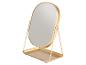Miroir de table ovale doré avec support et plateau.