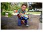 Un enfant joue dehors avec un grand camion jouet Hot Wheels Monster Trucks.
