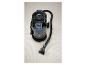 Nettoyeur de tapis noir avec tuyau et buse sur un tapis clair.